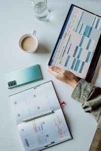 Therapist planning client growth strategies using a digital calendar and notebook